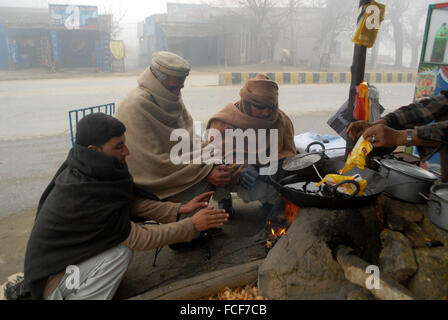 Peshawar. Il 22 gennaio, 2016. Persone sedersi intorno al fuoco durante la fitta nebbia nel nord-ovest del Pakistan a Peshawar, a gennaio 22, 2016. Nebbia fitta inghiottito diverse parti del Punjab e a Peshawar, causando il traffico stradale e i voli delle interruzioni. Credito: Umar Qayyum/Xinhua/Alamy Live News Foto Stock