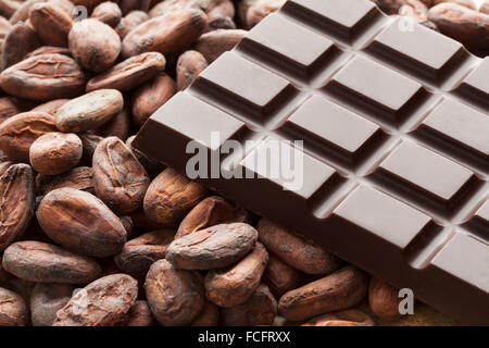 Barretta di cioccolato con materie prime fave di cacao Foto Stock