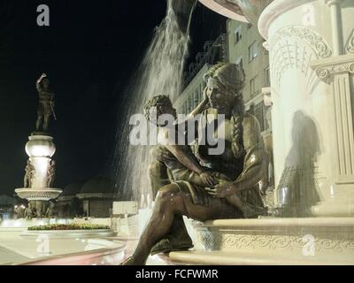 Grande fontana e le sculture in bronzo di adulti e bambini a Skopje in Macedonia, l'Europa. Foto Stock