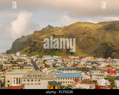 Grappolo di case di fronte alla montagna di Heimaey, Vestmannaeyjar, Islanda. Noto anche come le isole Westman. Foto Stock