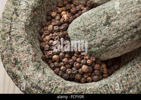 Tradizionale mortaio e pestello con secchi pepe nero close up Foto Stock