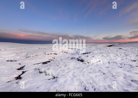 Snowy brughiera a fianco del The Pennine Way sopra Glossop nel Derbyshire su una splendida serata invernale al tramonto. Foto Stock