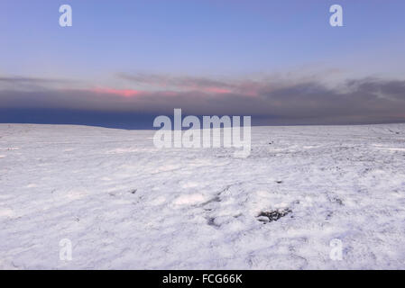 Snowy brughiera a fianco del The Pennine Way sopra Glossop nel Derbyshire su una splendida serata invernale al tramonto. Foto Stock