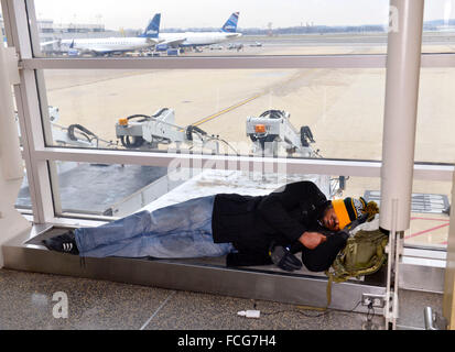 (160122) -- WASHINGTON D.C., il 22 gennaio 2016 (Xinhua) -- un passeggero prende un pisolino mentre aspetta il suo volo presso l'Aeroporto Nazionale Ronald Reagan di Washington, 22 gennaio 2016. Washington, DC e altri cinque Stati degli Stati Uniti lungo gli Stati Uniti Costa est di giovedì ha dichiarato lo stato di emergenza come era la regione stessa di controventamento in una storica tempesta di neve durante il fine settimana che è stato previsto per eseguire il dump di fino a 2 metri di neve. Le principali compagnie aeree hanno cominciato a cancellare voli per venerdì e sabato. Secondo FlightAware, un tracking voli site, almeno 2.000 voli il venerdì e un altro 3.000 sabato erano exp Foto Stock