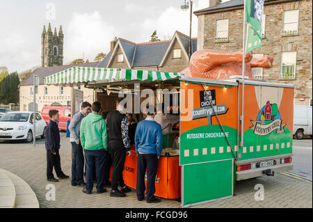 Gruppo di ragazzi in fila a un furgone di catering mobile, che vende prodotti a base di pollo, al Friday Market in the Square, Bantry, Irlanda. Foto Stock