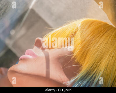 Giallo e blu capelli mannequin femminile in un negozio finestra anteriore in Manhattan, New York City, Stati Uniti d'America. Foto Stock