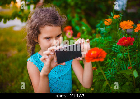 Teen ragazza di aspetto europeo sette anni fotografando flowe Foto Stock