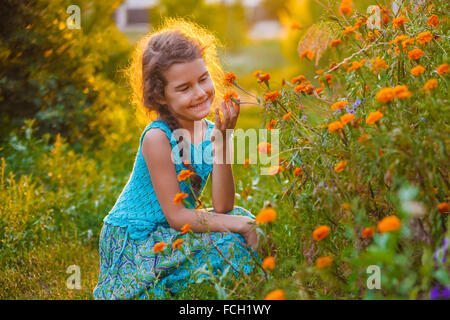 Teen ragazza di aspetto europeo sette anni con fiori in nat Foto Stock