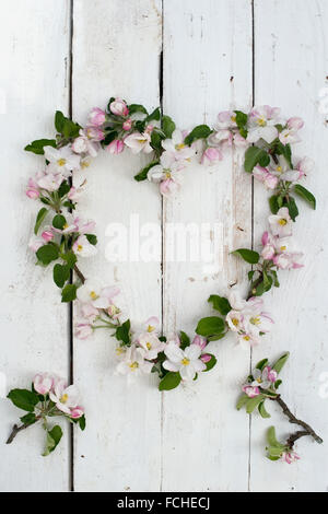 A forma di corona di fiori su legno bianco Foto Stock