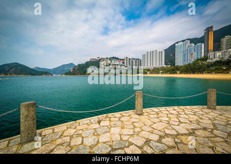 Vista dei grattacieli e la spiaggia da un molo a Repulse Bay, a Hong Kong, Hong Kong. Foto Stock