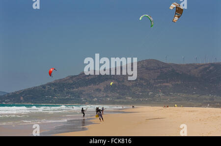 Gli sportivi del kite-surf sulla spiaggia pulita nel giorno di estate, Tarifa, Spagna Foto Stock