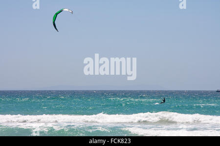 Sportsman kite surfer sulla spiaggia pulita nella giornata di vento, Tarifa, Spagna Foto Stock