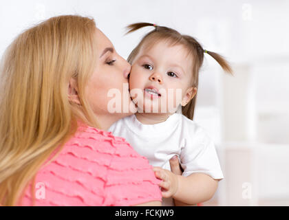 Ritratto di Madre bella baciare il suo bambino ragazza Foto Stock