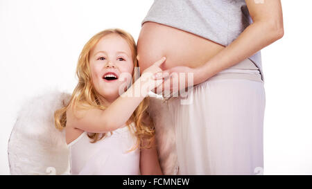 Bella bionda capelli modello angel hugs pancia in gravidanza. Foto Stock