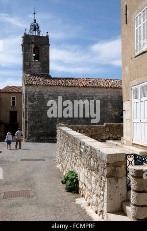 Due turisti di passeggiare nei pressi della chiesa nel villaggio provenzale di Mons, dipartimento del Var, Francia meridionale. Foto Stock