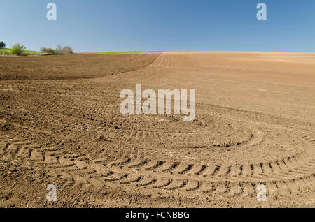 Campo Arato con tracce di trattore nel tempo primaverile Foto Stock