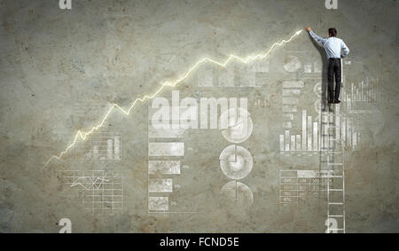 Imprenditore in piedi sulla scala disegno diagrammi e grafici Foto Stock