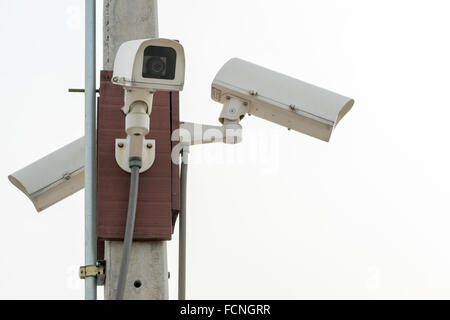 Tre di sorveglianza telecamere di sicurezza sul cielo bianco sfondo con copia spazio. Moderna tecnologia di sicurezza concept Foto Stock