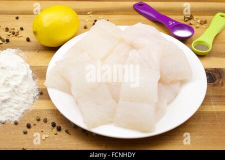 Pollock crudo pesce tagliato a fette e altri ingredienti per la frittura Foto Stock