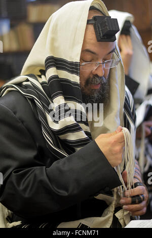 Una religiosa ebraica uomo portare una piccola Congregazione nella preghiera del mattino in Crown Heights, Brooklyn, New York Foto Stock