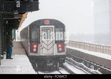 New York, Stati Uniti d'America. 23 gen 2016. Una elevata linea di lavaggio treno parte il Queensboro Plaza dalla stazione di New York durante la tempesta di neve Jonas su Sabato, 23 gennaio 2016. A causa di condizioni di blizzard avvicinando la MTA ha annunciato che sarà la sospensione di tutte al di sopra del suolo alla metropolitana come servizio di 4:00. Credito: Richard Levine/Alamy Live News Foto Stock