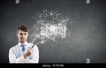 Bel giovane imprenditore che pensa alle idee e tubo di fumo Foto Stock