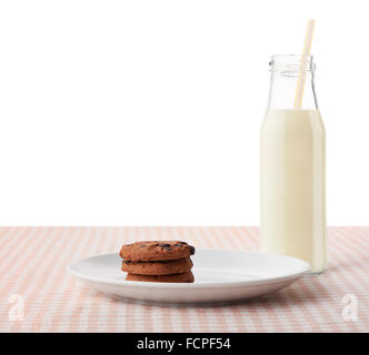 Pila di tre in casa i biscotti al cioccolato bianco su piastra in ceramica e una bottiglia di latte con paglia Pila di tre in casa i biscotti al cioccolato bianco su piastra in ceramica e una bottiglia di latte con paglia