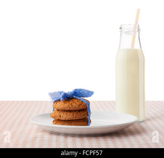 Pila di tre in casa i fiocchi d'avena cookie legate con nastro blu su bianco piastra ceramica e bottiglia di latte