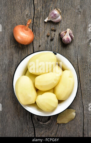 Sbucciate le patate e le verdure su sfondo di legno, vista dall'alto Foto Stock