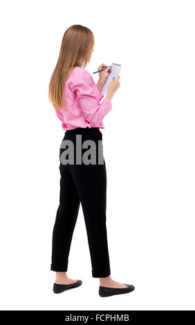 Vista posteriore di gabbie donna prende appunti in un notebook. ragazza guardando. Vista posteriore di raccolta persone. vista posteriore di persona. Isolato su sfondo bianco. Donna lavoratore di ufficio in una maglia rosa dipinge un pennarello sulla scheda. Foto Stock