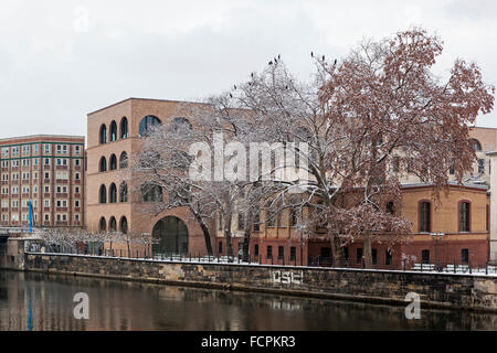 Berlino nuovi edifici di appartamenti e cormorani in coperta di neve alberi vicino al fiume Spree in inverno Foto Stock