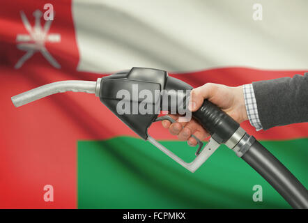 Pompa carburante ugello in mano con bandiera su sfondo - Oman Foto Stock