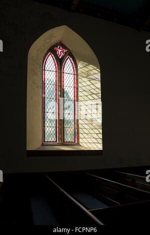 La finestra della chiesa con la luce del sole proveniente attraverso il riquadro di diamante di vetro. St Edmund la chiesa parrocchiale in Castleton, Derbyshire. Foto Stock