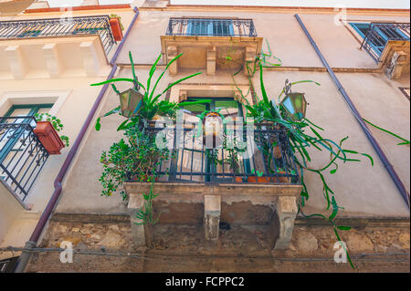 Balcone di Taormina, vista su una colorata esposizione di piante e ceramiche su un balcone di appartamenti in una strada nel centro storico di Taormina, Sicilia. Foto Stock
