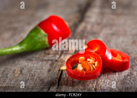 Peperoncino rosso fette su sfondo di legno Foto Stock