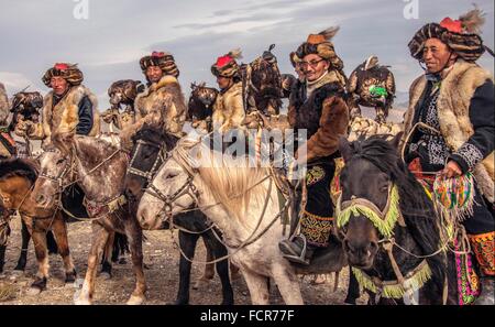 Il kazako Burkitshi pongono cacciatori a cavallo durante il Mongolian Golden Eagle Festival in Olgii, Mongolia. Foto Stock