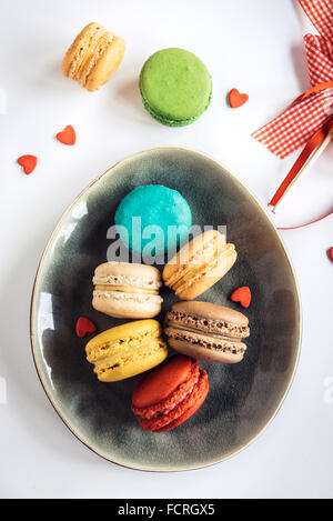 Servita colorato amaretti cookies nella piastra su sfondo bianco,fuoco selettivo Foto Stock