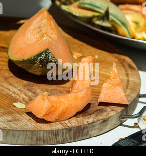 Orange melone freschi fette di melone sul vassoio in legno Foto Stock