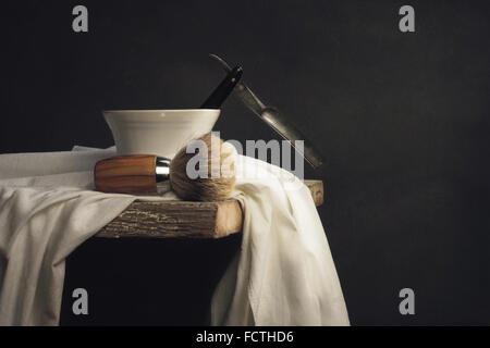 Vintage Strumento di rasatura sul tavolo di legno e uno sfondo scuro Foto Stock