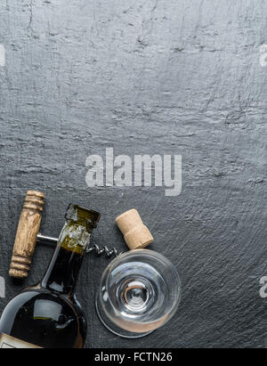 Bottiglia di vino, bicchiere di vino e un cavatappi sulla scheda di grafite. Foto Stock