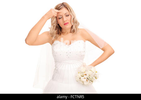 Studio shot di una giovane sposa in bianco di un abito da sposa con un mal di testa isolata su sfondo bianco Foto Stock