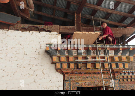 Un monaco lavora a un tempio vicino a Thimphu Bhutan Foto Stock