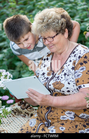 La nonna con nipote guardando un tablet PC Foto Stock