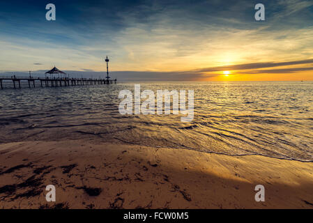 La gente camminare e pesca sul molo al tramonto. Colore effetti tonificanti applicato Foto Stock