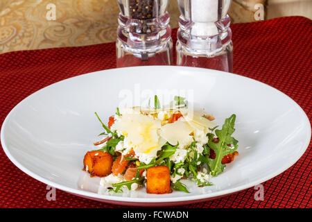 Creative insalata di salmone e formaggio con erbe su una piastra bianca Foto Stock