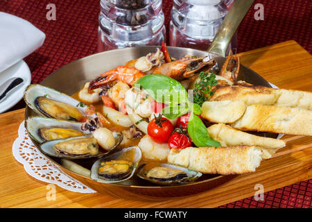 Cocktail a base di pesce, calamari, cozze, gamberi in una padella il serving table Foto Stock