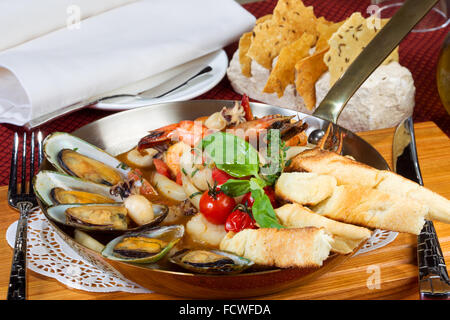 Cocktail a base di pesce, calamari, cozze, gamberi in una padella il serving table Foto Stock