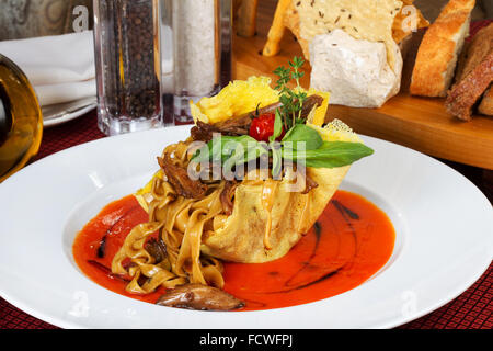 Le lasagne italiane con pomodoro e verdure e salsa su una piastra bianca Foto Stock