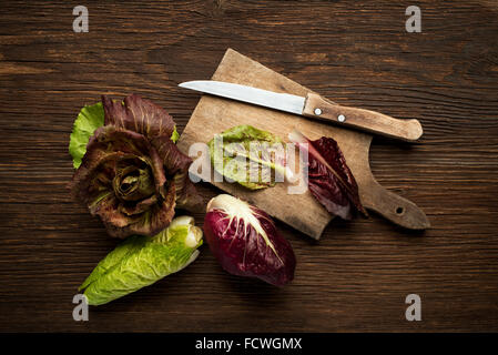 Fresco radicchio misto su un sfondo di legno. Foto Stock