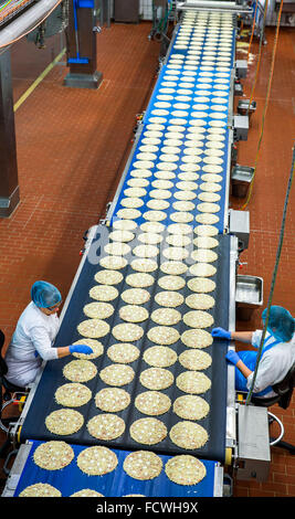 Wittenburg, Germania. 08 Dic, 2015. I dipendenti ispezionare la base usata per pizze surgelate in corrispondenza di una linea di produzione della pizza impianto del produttore di alimenti Dr. Oetker a Wittenburg, Germania, 08 dicembre 2015. In base alle proprie informazioni, la società con i suoi 900 dipendenti è uno dei più grandi datori di lavoro dello Stato tedesco Meclemburgo-Pomerania occidentale. Foto: Jens BUETTNER/dpa/Alamy Live News Foto Stock